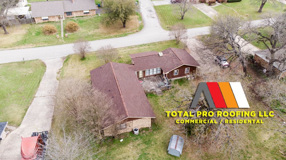 Aerial view of a residential property with Total Pro Roofing logo in the foreground.