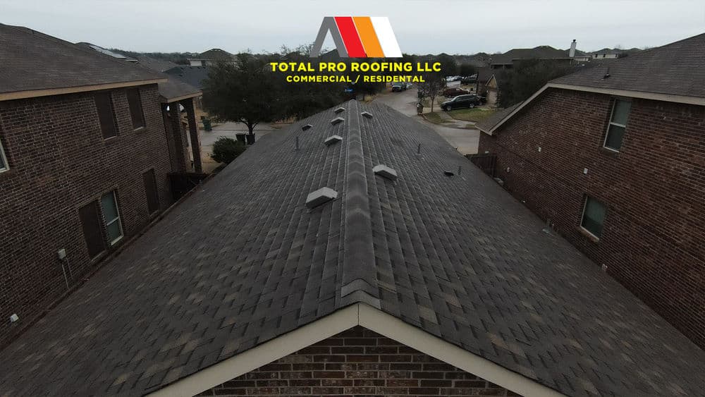 Aerial view of dark shingle roof on residential buildings by Total Pro Roofing LLC.