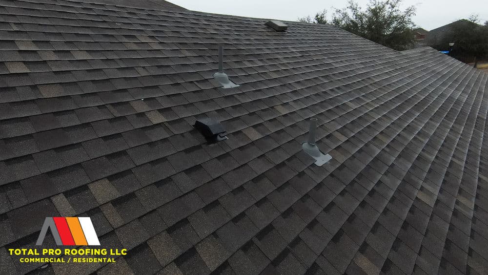 Roofing installation with vents on a textured asphalt shingle roof by Total Pro Roofing LLC.