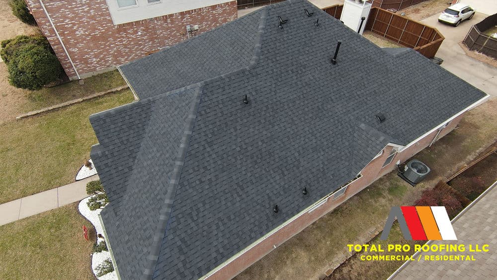 Aerial view of a residential roof with dark shingles by Total Pro Roofing LLC.