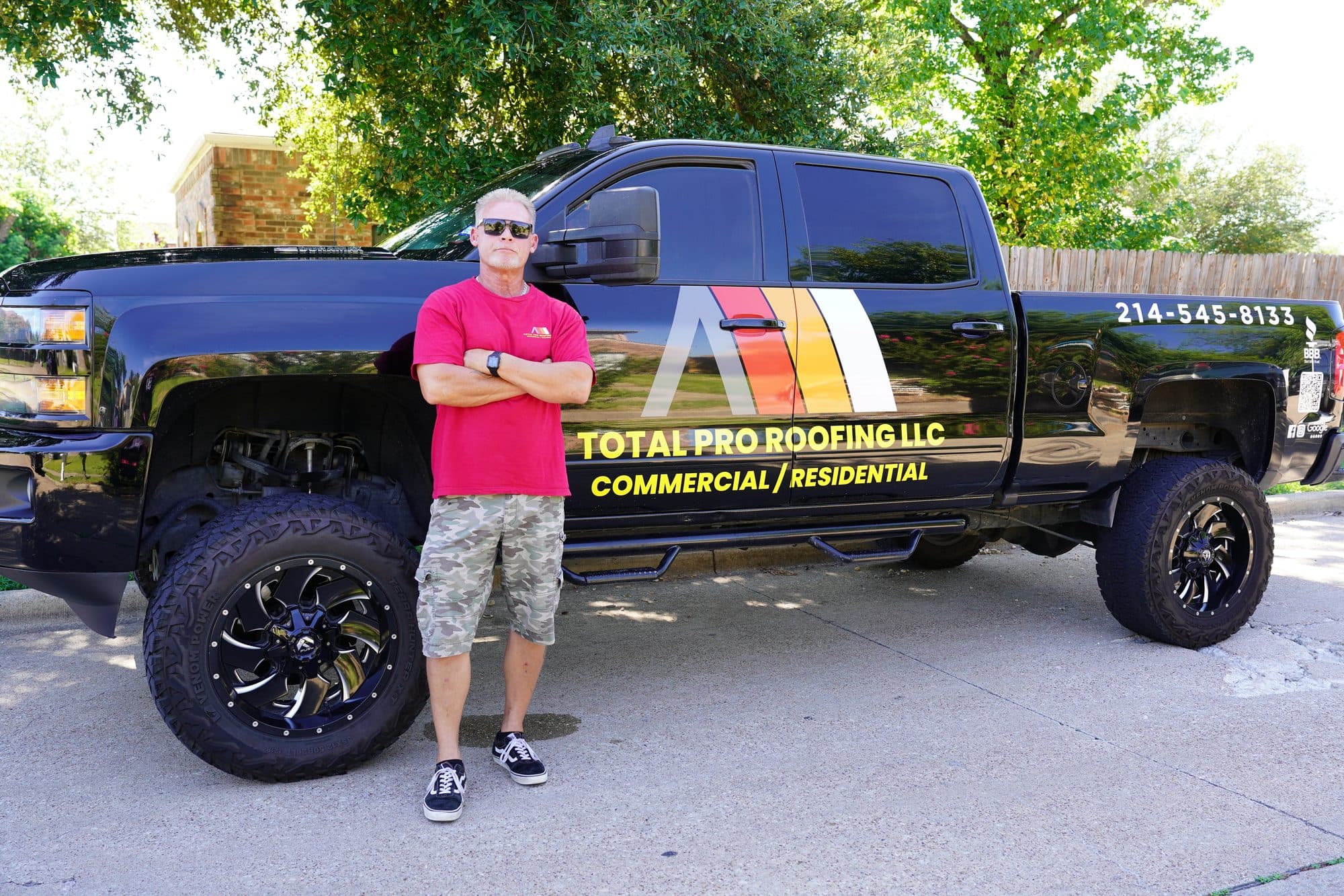Duane Huddleston standing beside the Total Pro Roofing truck